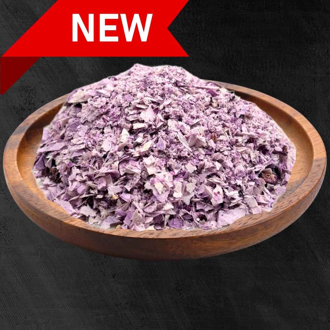 Photo of Carnevore Mountain freeze dried organic yogurt and organic wild blueberries in a brown wooden bowl with a black textured background.