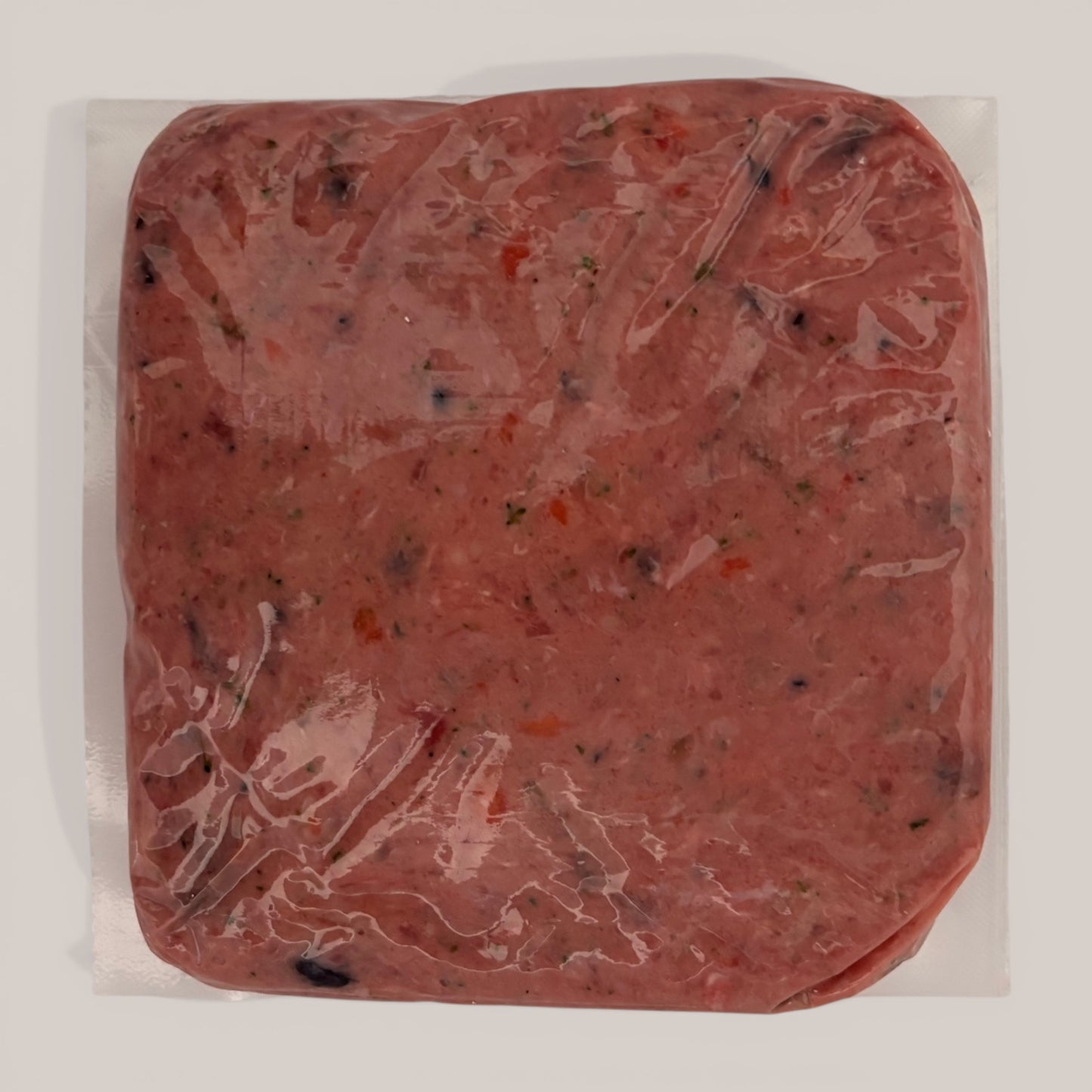 Back of Carnevore Mountain Duck and Turkey raw dog food in plastic packaging on a white background